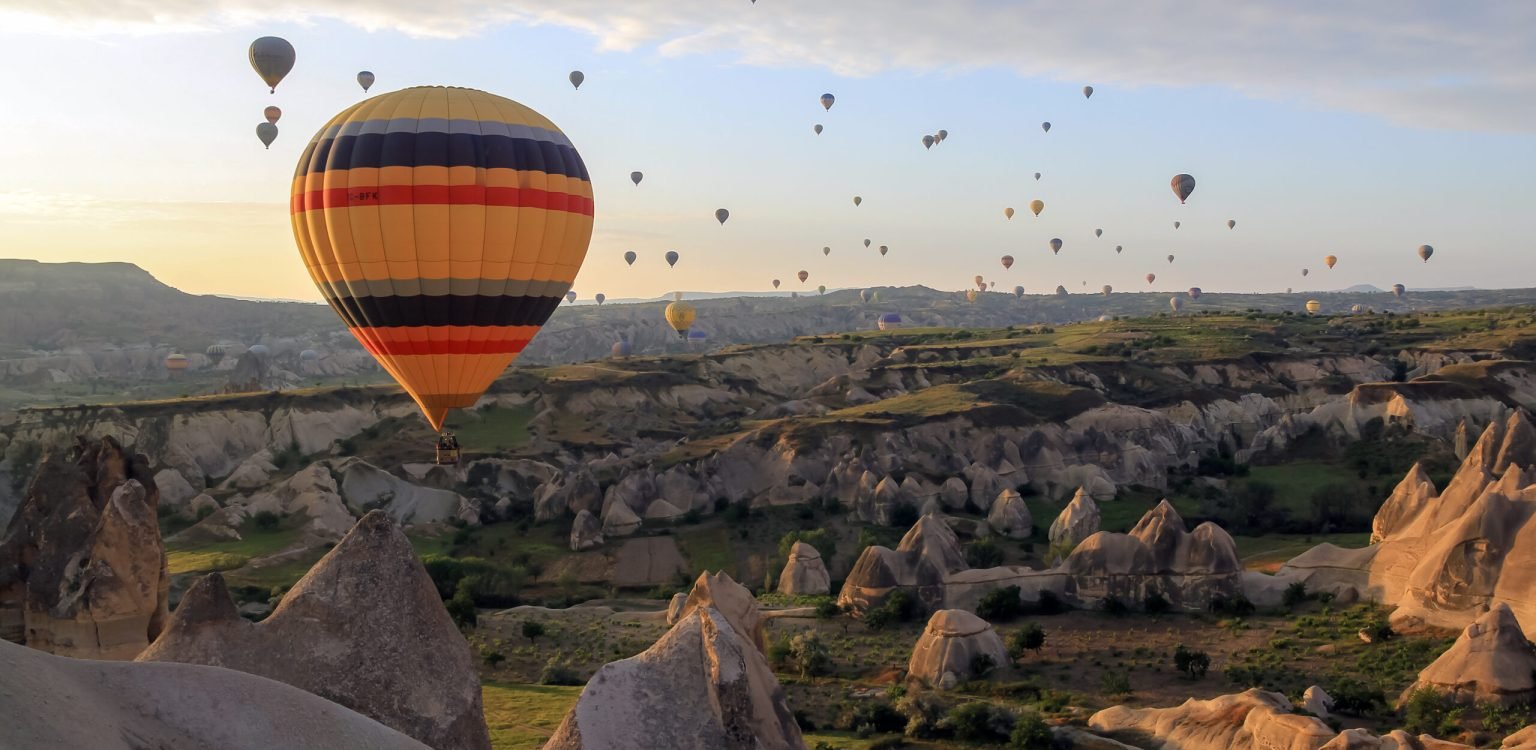 Air baloons flying at sunrise in Cappadocia Cappadocia Travel Guide- Hot Air Baloon