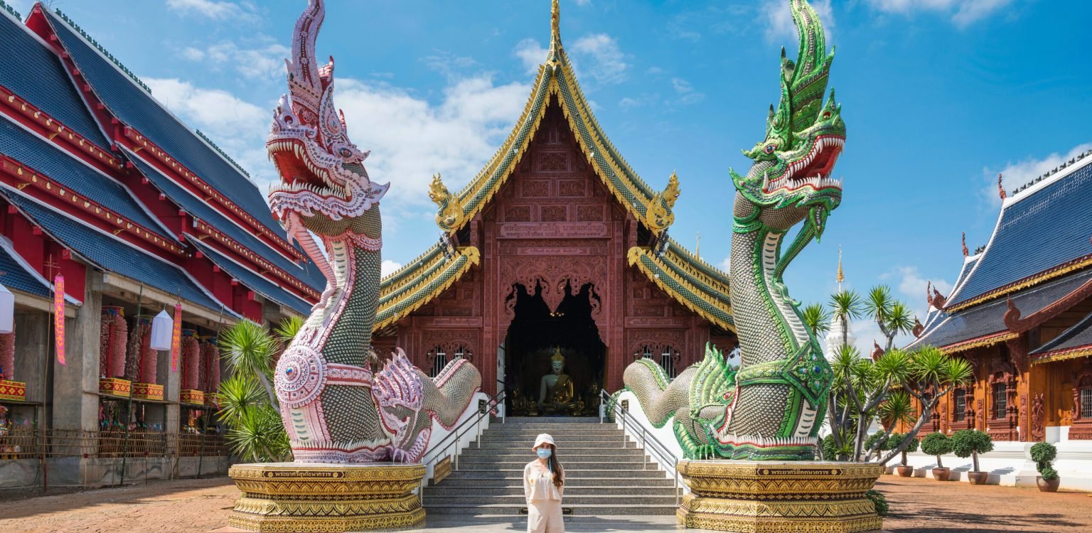 Asian female tourist come to worship at Wat Ban Den or Wat Den S Asian female tourist come to worship at Wat Ban Den or Wat Den Salee Sri Muang Gan the Lanna style temple and colorful statue sculpture in sunny day at Chiang Mai, Thailand