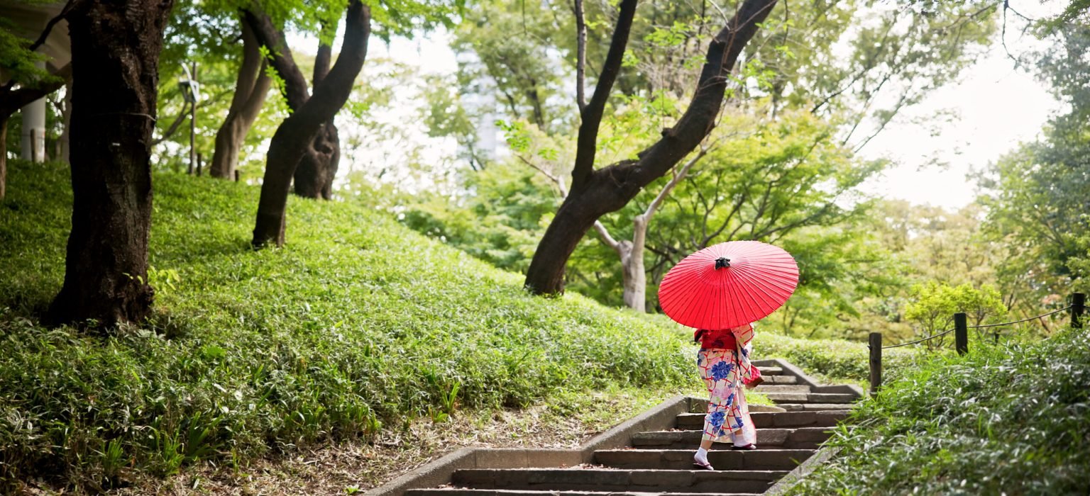 Kimono, park and umbrella with woman on steps to explore green location for sightseeing or tourism