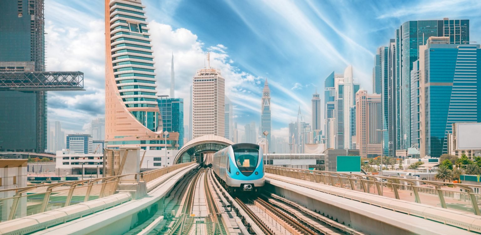 Monorail Subway train rides among glass skyscrapers in Dubai. Traffic on street in Dubai. Cityscape skyline. Urban background Monorail Subway train rides among glass skyscrapers in Dubai. Traffic on street in Dubai. Cityscape skyline. Urban background. Altered sky.