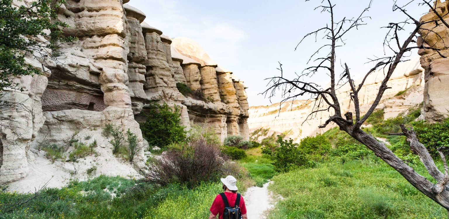 tourist walks in ravine near Goreme in Cappadocia Travel to Turkey - tourist walks in ravine near Goreme town in Cappadocia in spring